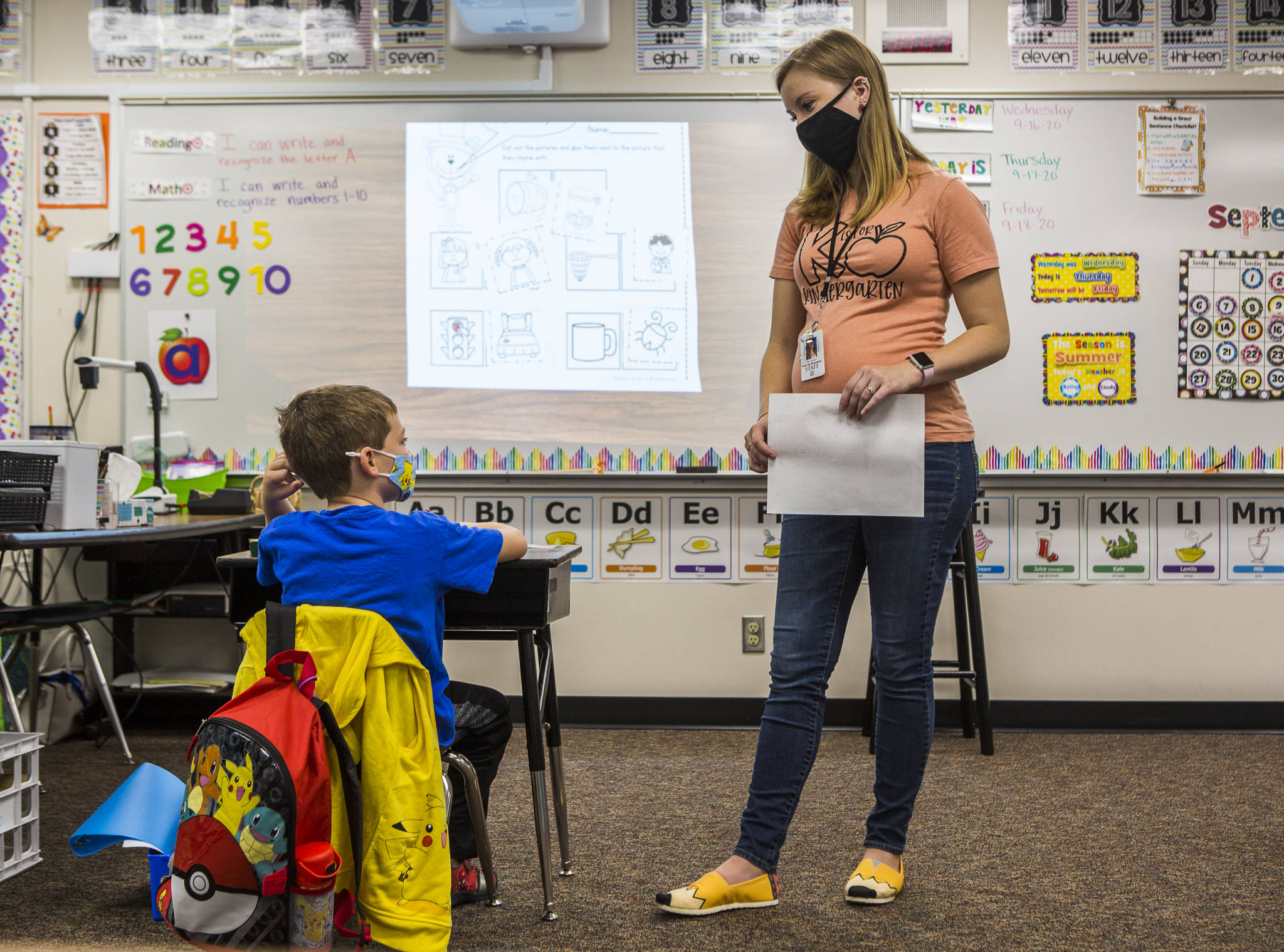 Kindergarten teacher Kari Richards answers a question from one of her three masked and socially distanced students during class at Twin City Elementary School on Thursday in Stanwood. (Olivia Vanni / The Herald)