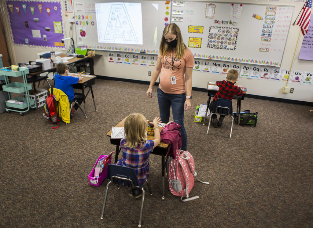 Kari Richards walks around to her three students in class at Twin City Elementary School on Thursday in Stanwood. (Olivia Vanni / The Herald)
