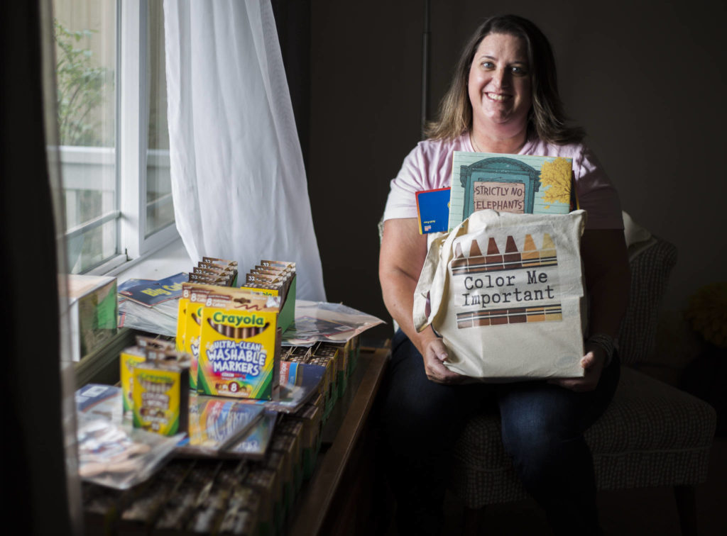 Marnie Gray, who launched a school supply effort called Color Me Important, shows some of the materials Thursday at her in Lake Stevens. (Olivia Vanni / The Herald)
