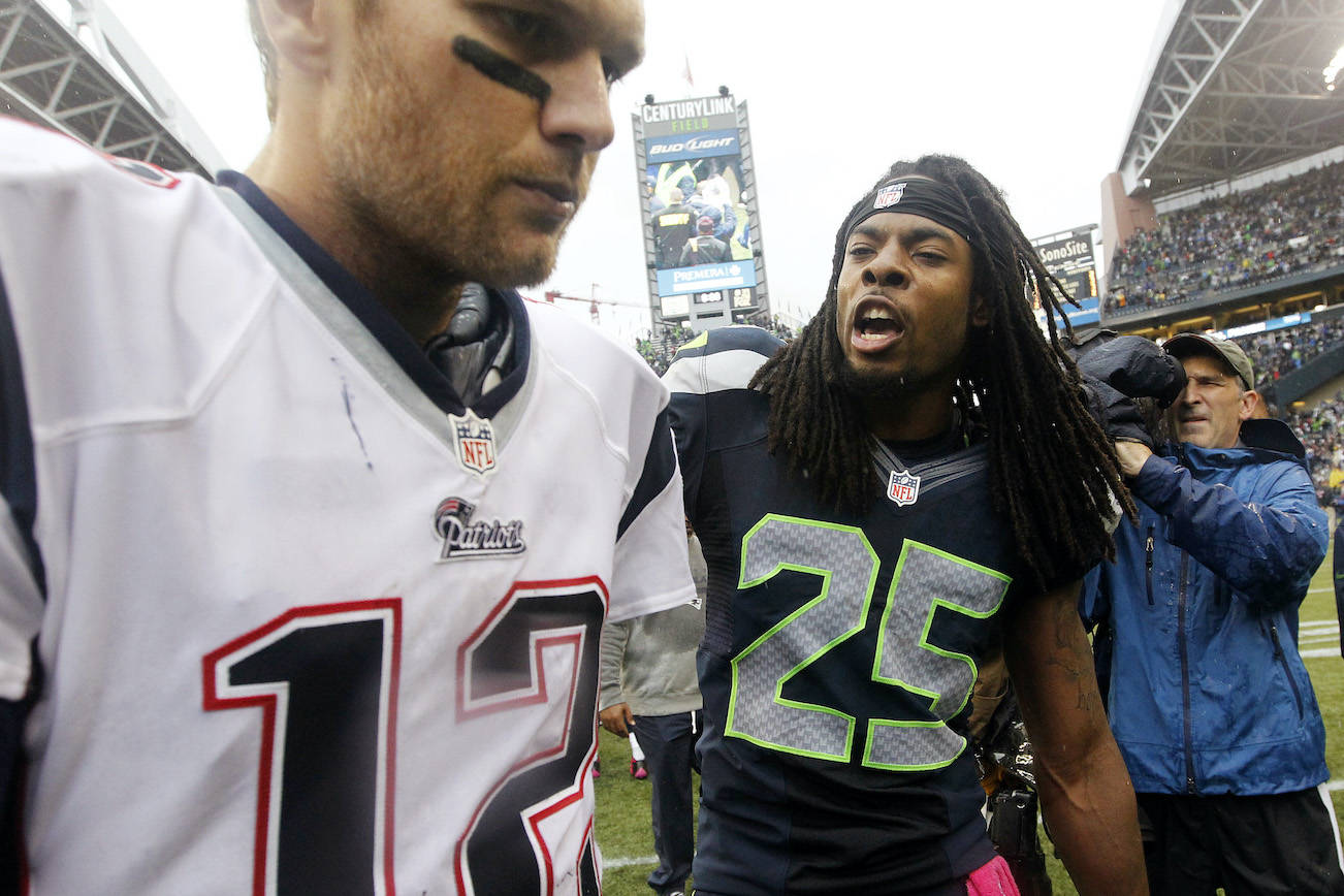 In this Oct. 14, 2014, file photo, the Seattle Seahawks’ Richard Sherman (25) talks with New England Patriots quarterback Tom Brady after the Seahawks won 24-23 at CenturyLink Field. (AP Photo/Elaine Thompson)