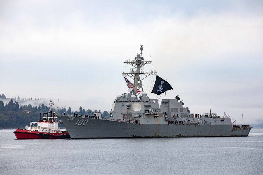 The USS Kidd pulls into its homeport at Naval Station Everett Monday morning, flying a Jolly Roger flag. Dozens on the ship contracted COVID-19 during the nearly nine-month long deployment. (U.S. Navy photo by Mass Communication Specialist 3rd Class Ethan Soto/Released)
