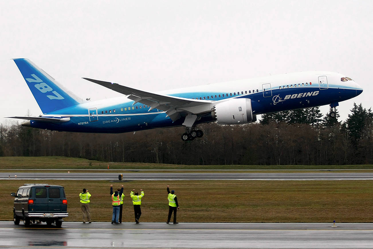 Worker cheer and wave as Boeing's 787 Dreamliner takes off from Paine Field Tuesday morning on Dec. 15, 2009. (Justin Best/ The Herald
