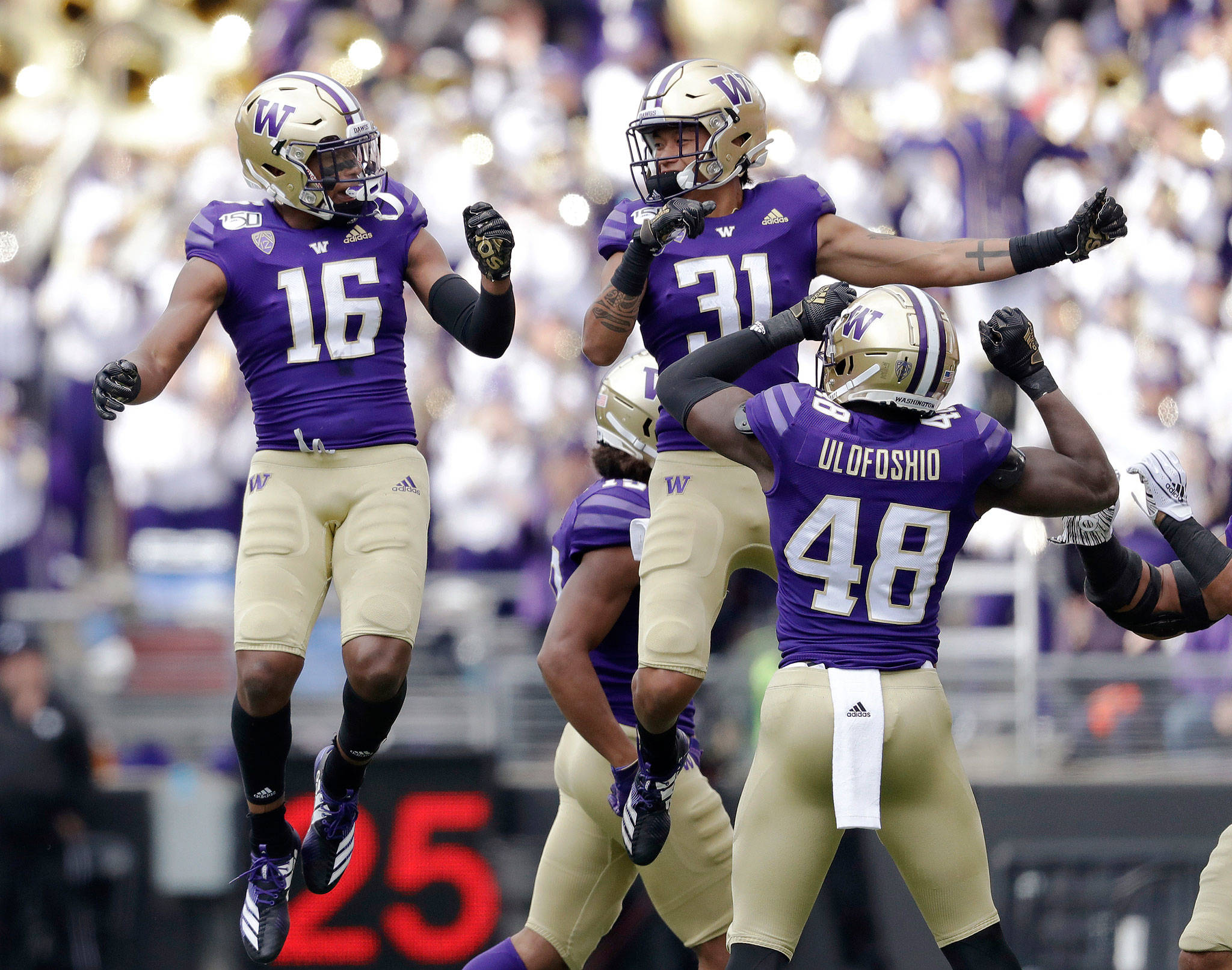 Washington’s Cameron Williams (16) celebrates his interception with teammate Kamren Fabiculanan (31) during the first half of a game against USC on Sept. 28, 2019, in Seattle. (AP Photo/Elaine Thompson)