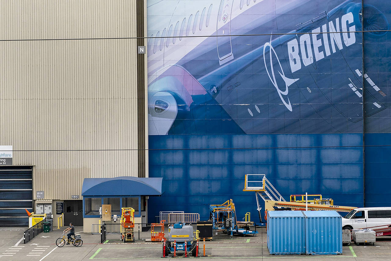 A worker rides a bicycle outside of the Boeing Co. facility in Everett on July 24. (David Ryder/Bloomberg, file)