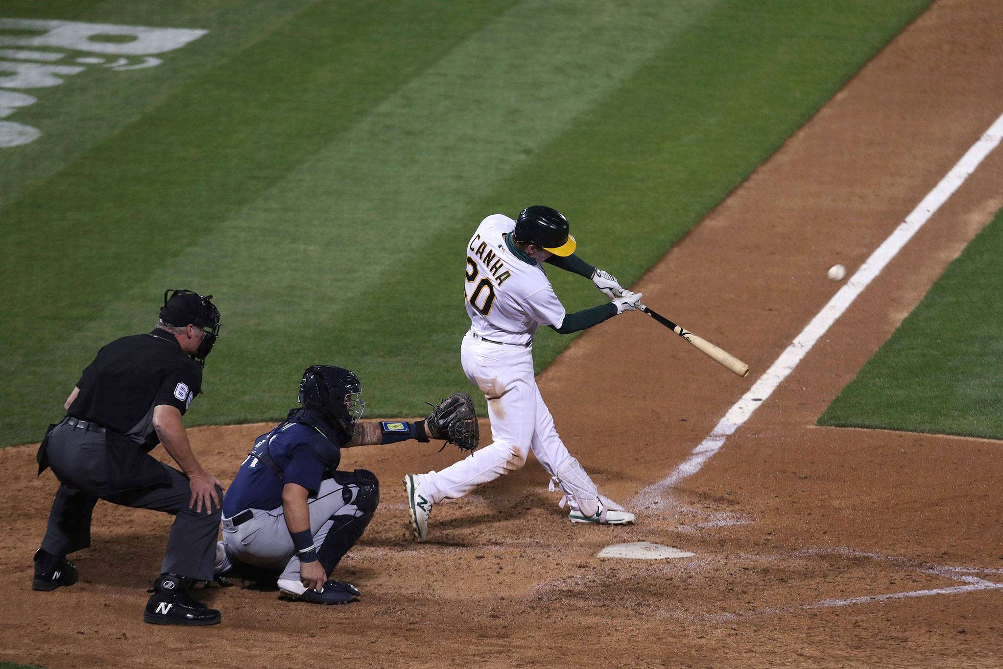 The Athletics’ Mark Canha hits a game-ending, two-run home run against the Mariners during the 10th inning of a game Friday in Oakland, Calif. (AP Photo/Jed Jacobsohn)