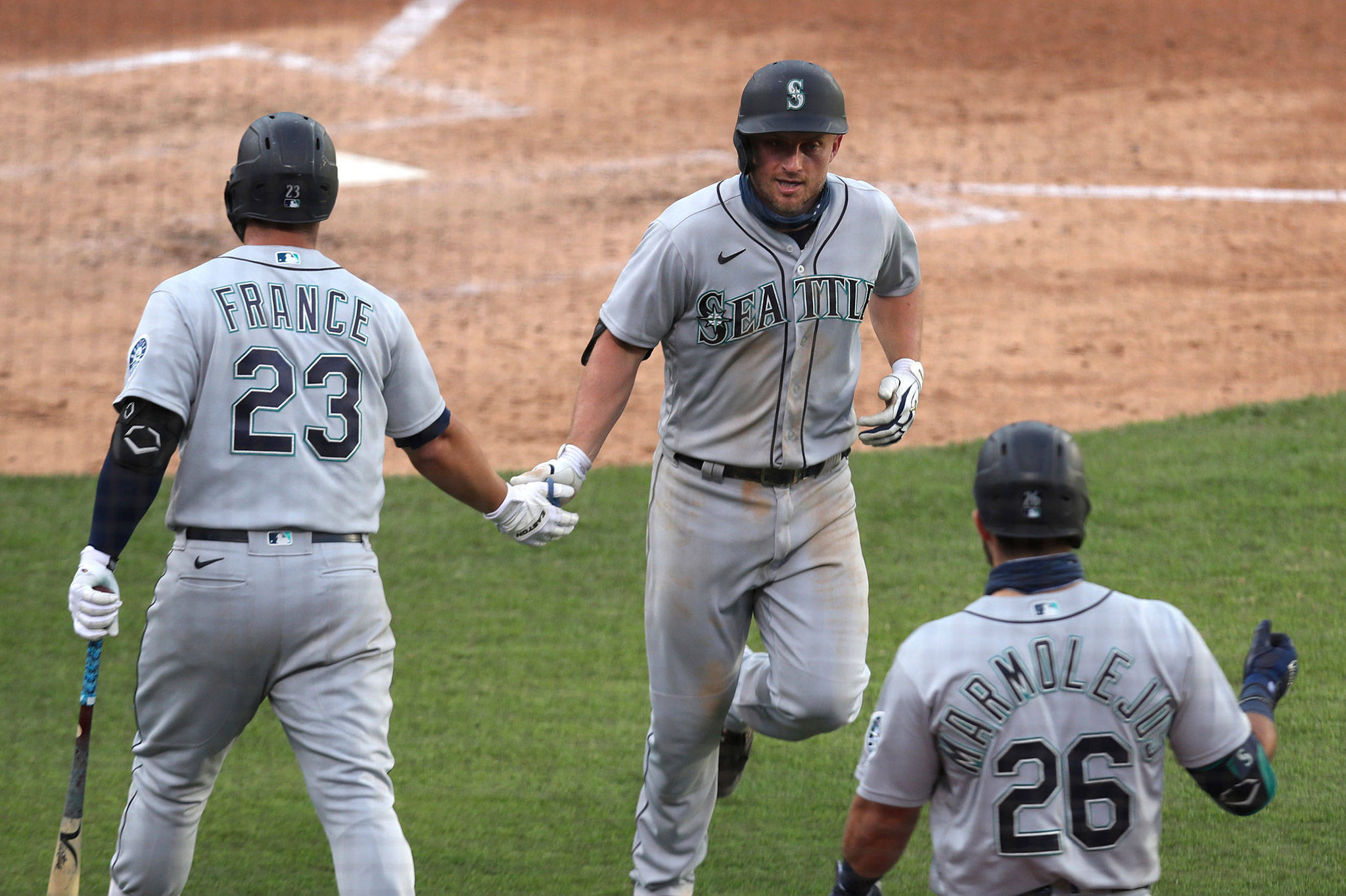 The Mariners’ Kyle Seager (center) celebrates with teammates Ty France and José Marmolejos after hitting a solo home run during the fourth inning of the second game of a doubleheader against the Athletics on Sept. 26, 2020, in Oakland, Calif. (AP Photo/Jed Jacobsohn)