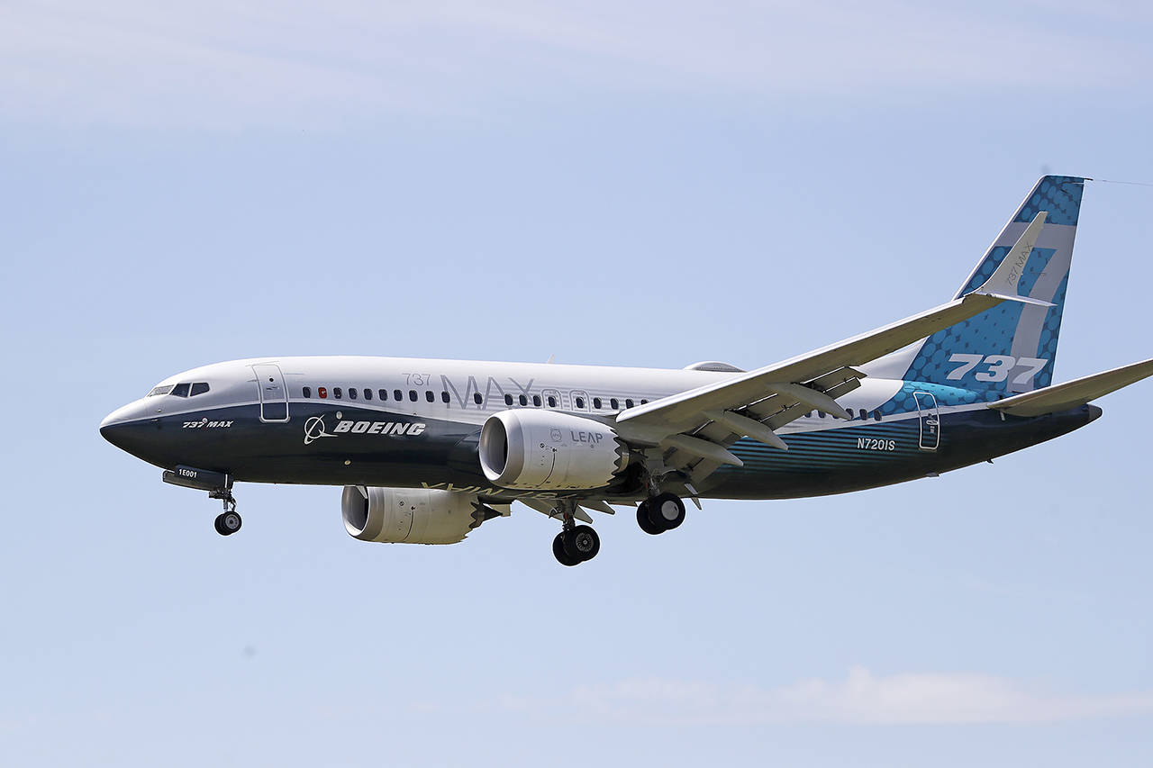 In this June 29 photo, a Boeing 737 Max jet heads to a landing at Boeing Field following a test flight in Seattle. (AP Photo/Elaine Thompson, File)