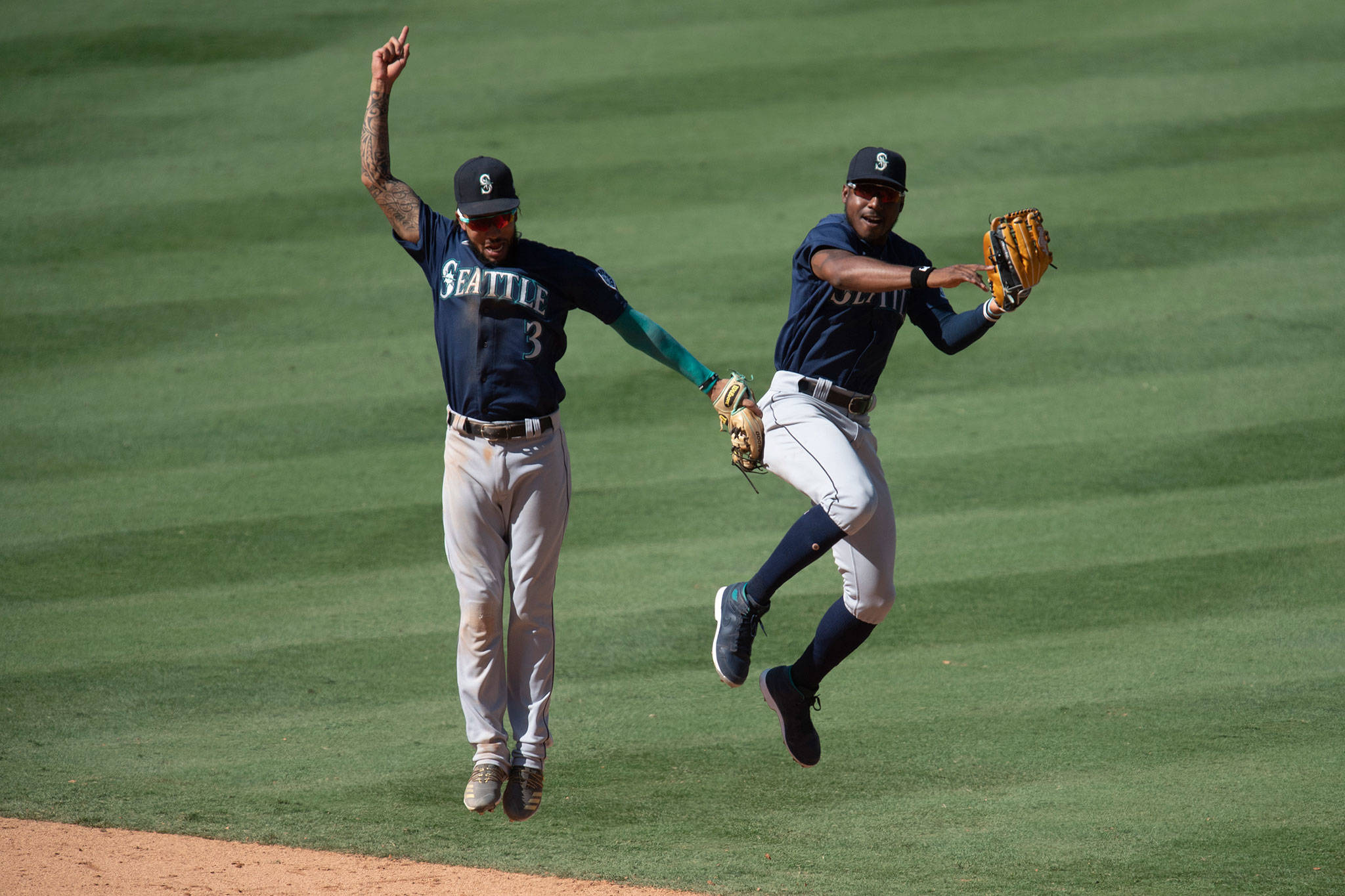 Mariners shortstop J.P. Crawford (left) and center fielder Kyle Lewis celebrate a win over the Angels on Aug. 31, 2020, in Anaheim, Calif. (AP Photo/Kyusung Gong)