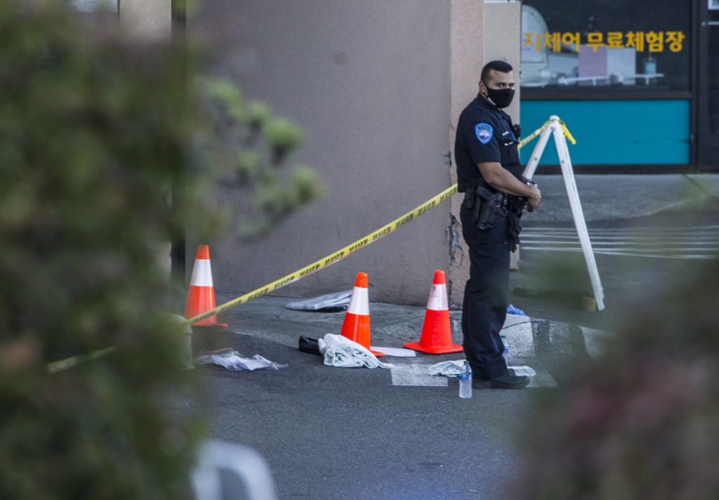 A police officer stands outside of Boohan Oriental Market after a shooting on Tuesday in Edmonds. (Olivia Vanni / The Herald)
