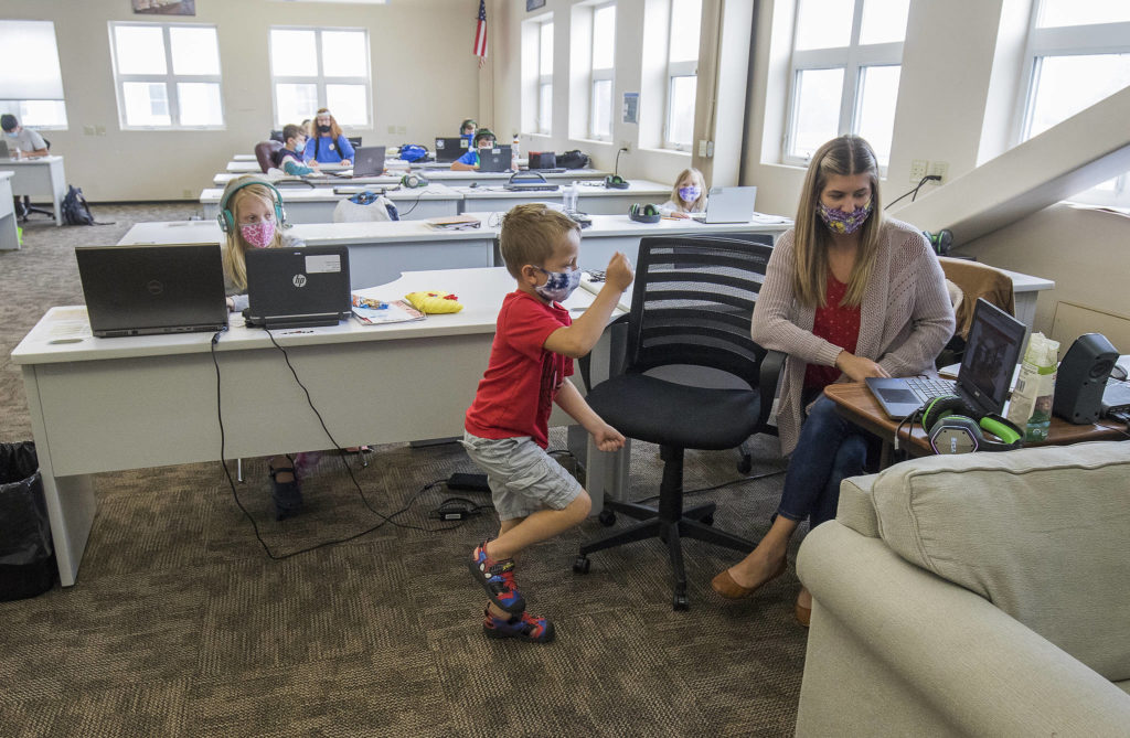 While teacher Kaylah Krueger watches, Landyn Bogart records himself “running” as part of an assignment on verbs at Electroimpact in Mukilteo. (Andy Bronson / The Herald)
