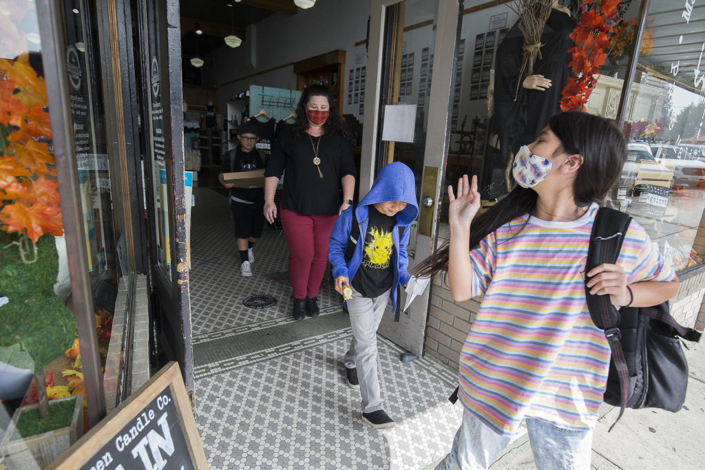 Hope Elliott waves goodbye as she, her classmates and teacher leave through the front door of Malicious Women Co. The students are the children of employees of the Snohomish business. (Andy Bronson / The Herald) 
