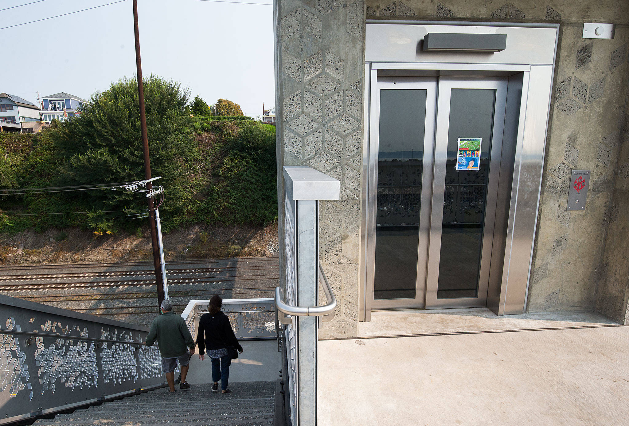 A couple takes the stairs near the Grand Avenue Park Bridge elevator Sept. 30 in Everett. The elevator was out of service for a couple of days when the door was damaged between the evening of Sept. 18 and morning of Sept. 19. (Andy Bronson / The Herald)