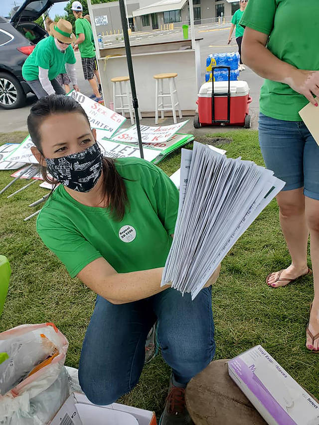 Stephanie Jerdon with A Voice for Washington Children holds a stack of signed petitions for Referendum 90 at the group’s celebration in the Spokane Valley on June 2. (A Voice for Washington Children)