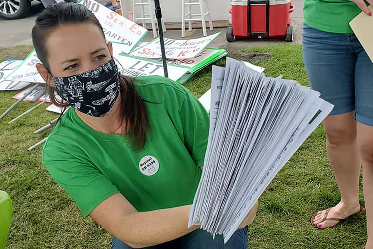 Stephanie Jerdon with A Voice for Washington Children holds a stack of signed petitions for Referendum 90 at the group’s celebration in the Spokane Valley on June 2. (A Voice for Washington Children)