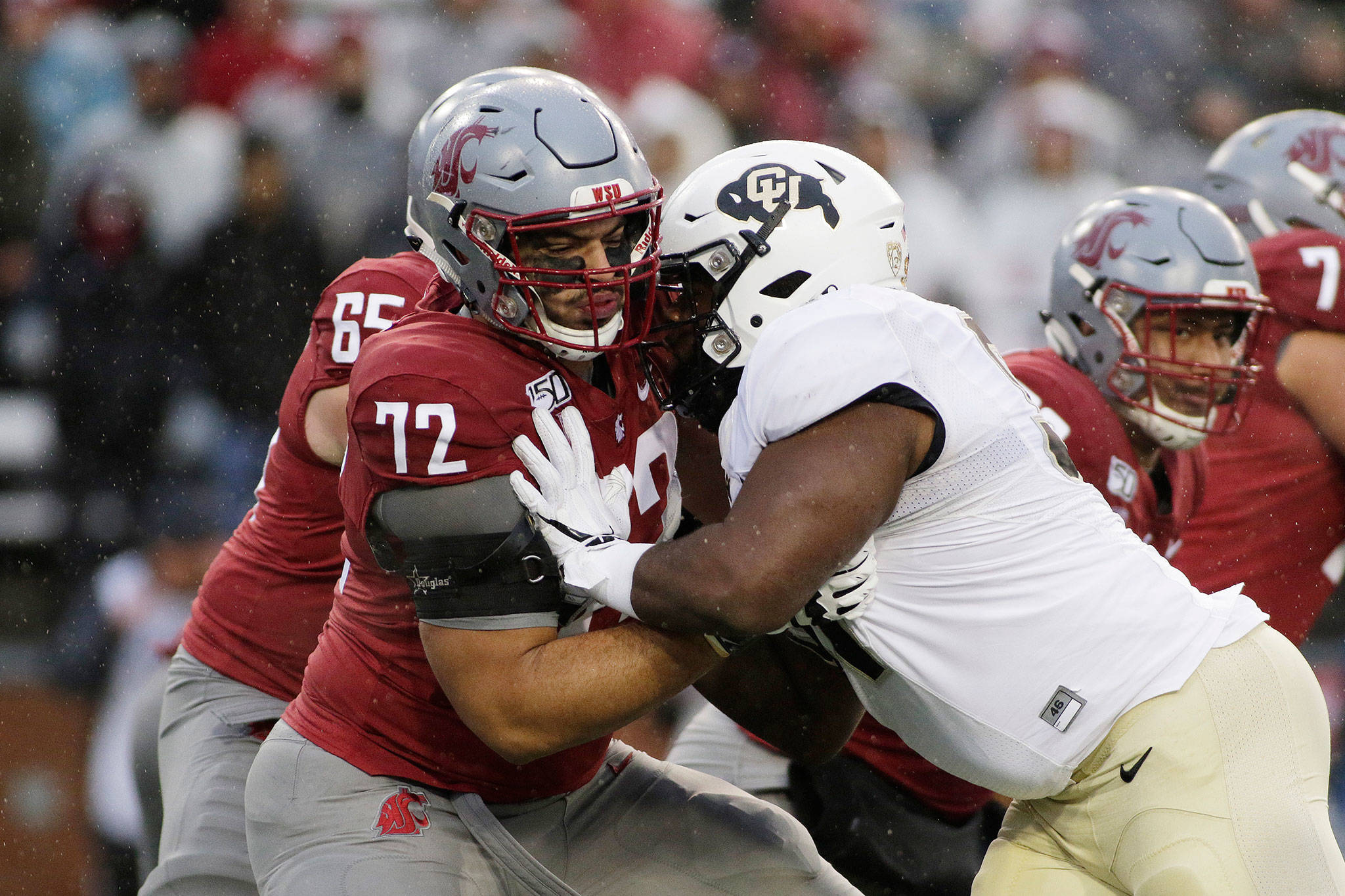 Washington State offensive lineman Abraham Lucas (left), an Archbishop Murphy alum, blocks Colorado defensive tackle Na’im Rodman during the first half of a game Oct. 19, 2019, in Pullman. (AP Photo/Young Kwak)
