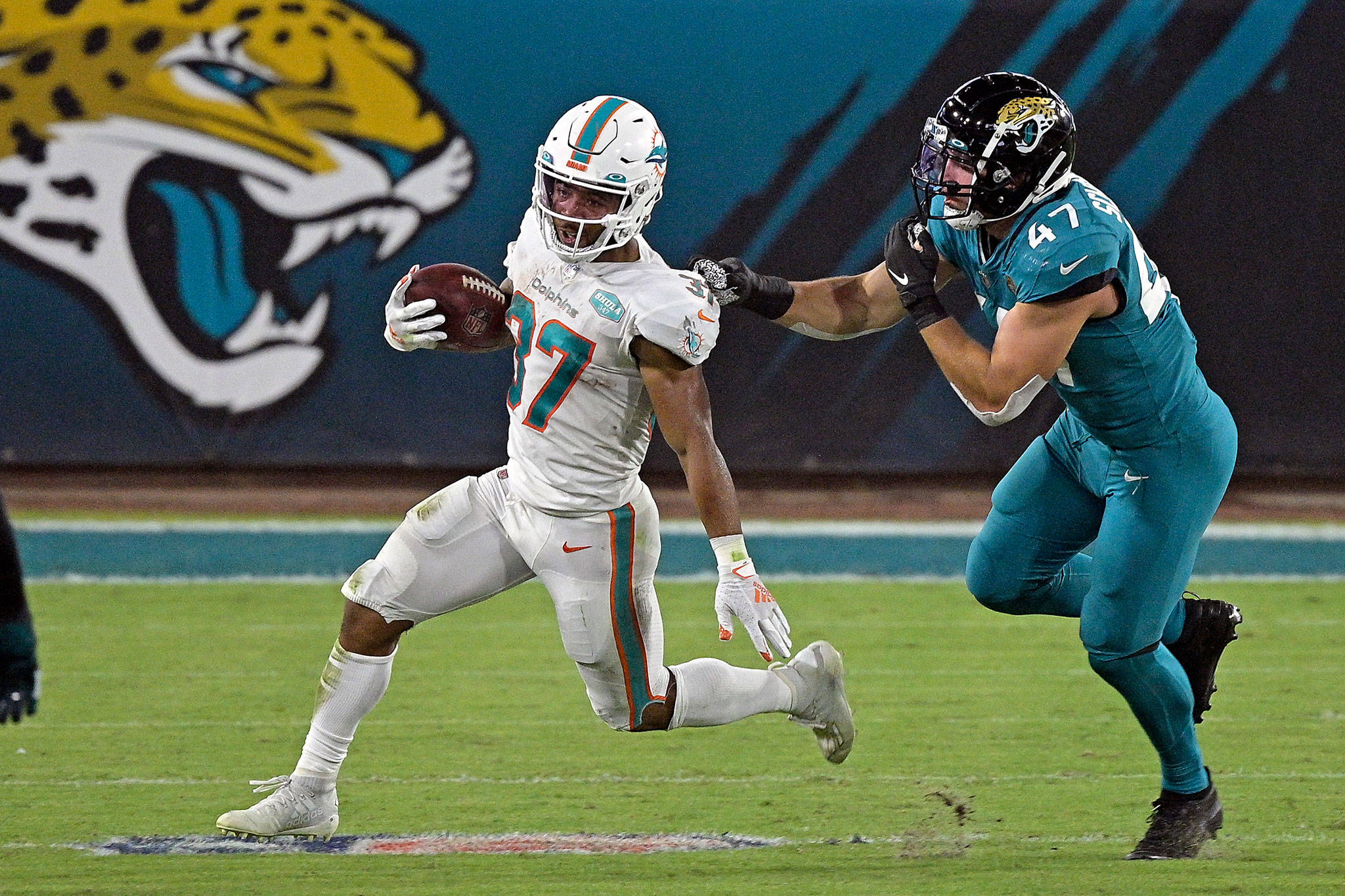 Dolphins running back Myles Gaskin, a Washington alum and Lynnwood native, runs past Jaguars middle linebacker Joe Schobert (47) during the first half of a game Sept. 24, 2020, in Jacksonville, Fla. (AP Photo/Phelan M. Ebenhack)