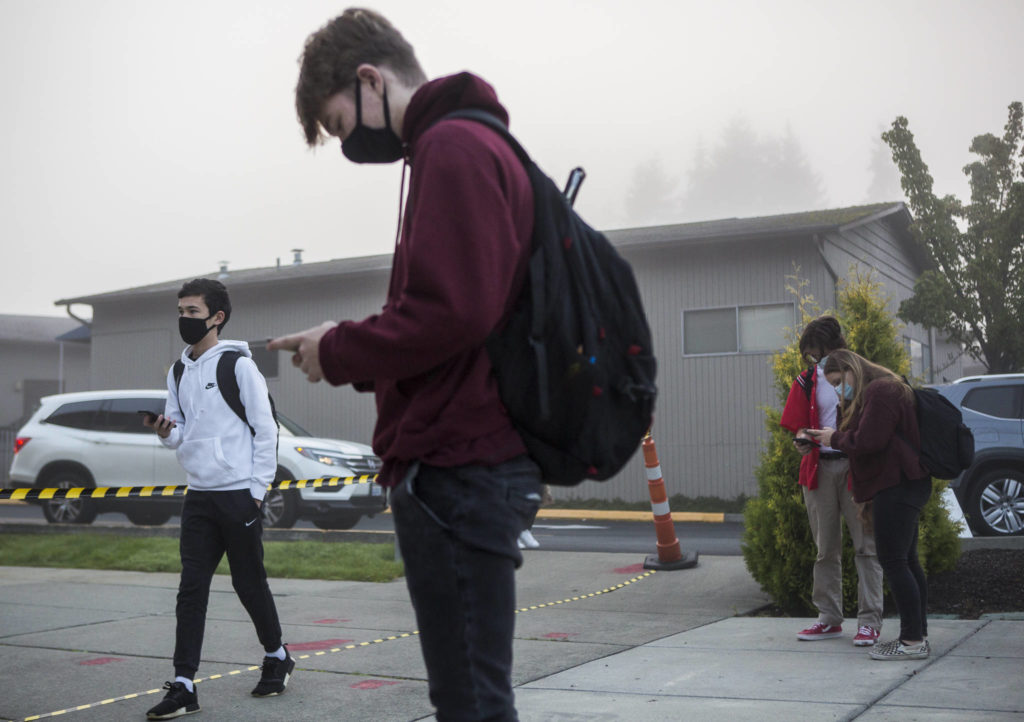 Students fill out their online health questionnaire before getting their temperatures checked at Archbishop Murphy on Tuesday in Everett. (Olivia Vanni / The Herald)
