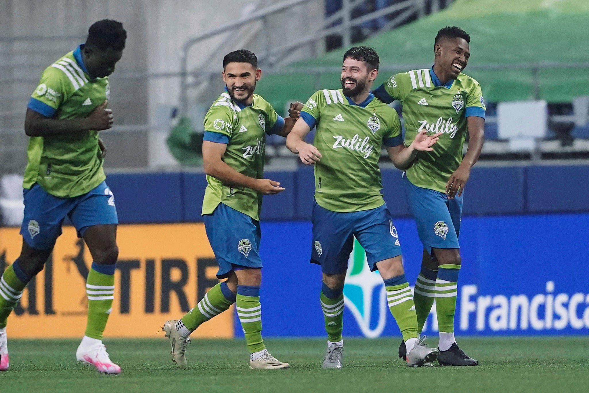 Sounders midfielder Joao Paulo (second from right) celebrates with Kelvin Leerdam (right) and Cristian Roldan after Paulo scored against the Vancouver Whitecaps during the second half of an MLS match on Oct. 3, 2020, in Seattle. (AP Photo/Ted S. Warren)