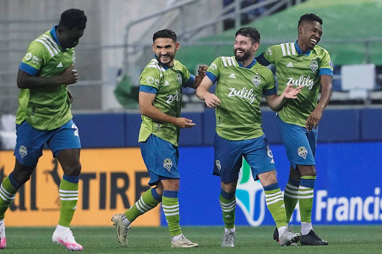 Seattle Sounders midfielder Joao Paulo, second from right, celebrates with Kelvin Leerdam, right, and Cristian Roldan, third from right, after Paulo scored against the Vancouver Whitecaps during the second half of an MLS soccer match Saturday, Oct. 3, 2020, in Seattle. (AP Photo/Ted S. Warren)