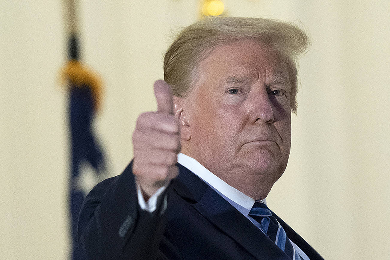 President Donald Trump gives thumbs up from the Blue Room Balcony upon returning to the White House Monday, Oct. 5, 2020, in Washington, after leaving Walter Reed National Military Medical Center, in Bethesda, Md. Trump announced he tested positive for COVID-19 on Oct. 2. (AP Photo/Alex Brandon)