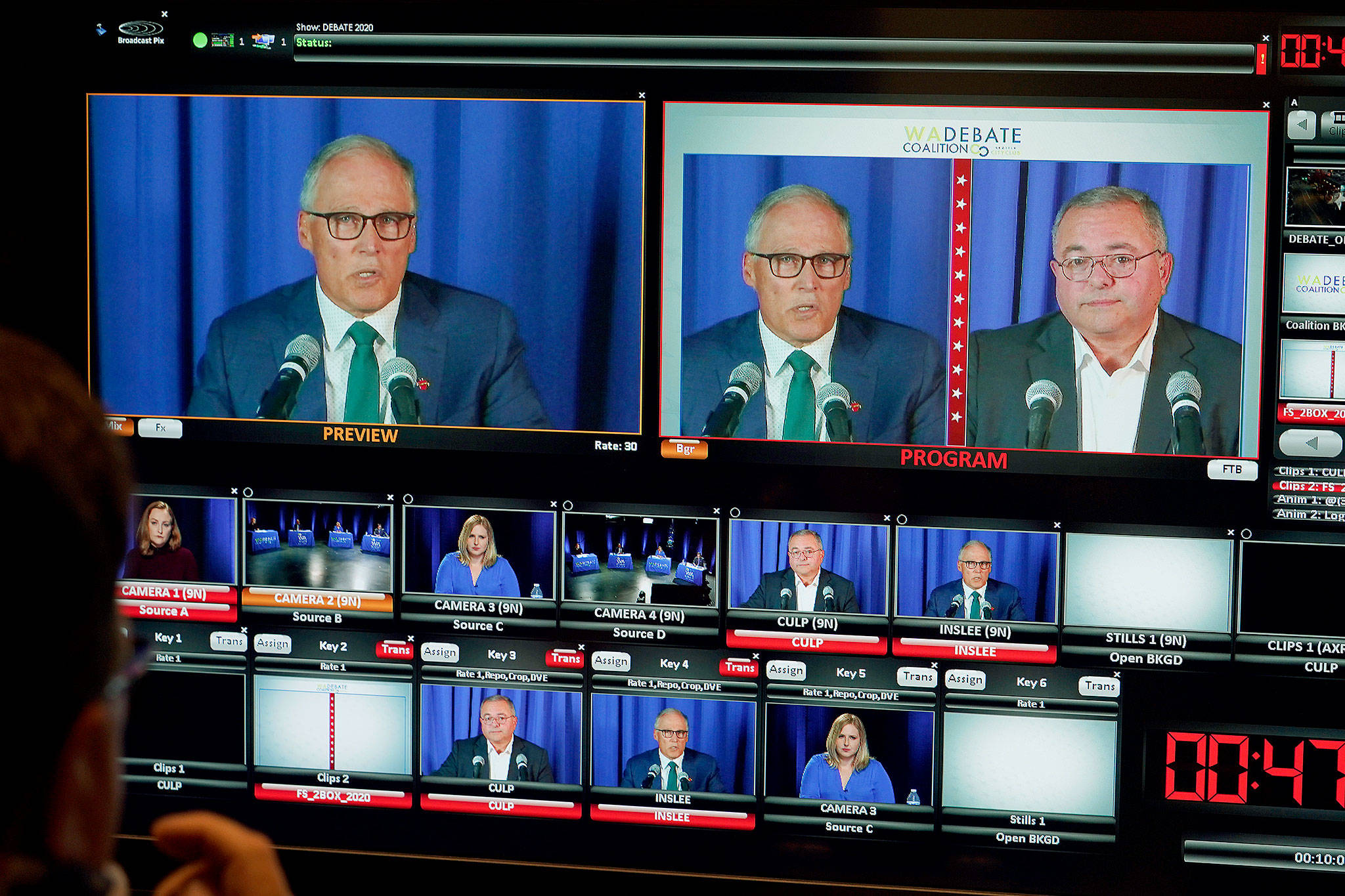 Washington gubernatorial candidates Gov. Jay Inslee (left), a Democrat, and Loren Culp, a Republican, are seen on a monitor in a video control room at the studios of TVW on Wednesday in Olympia as they take part in a debate. Due to concerns over COVID-19, each candidate took part from individual rooms, separate from moderators. (AP Photo/Ted S. Warren)