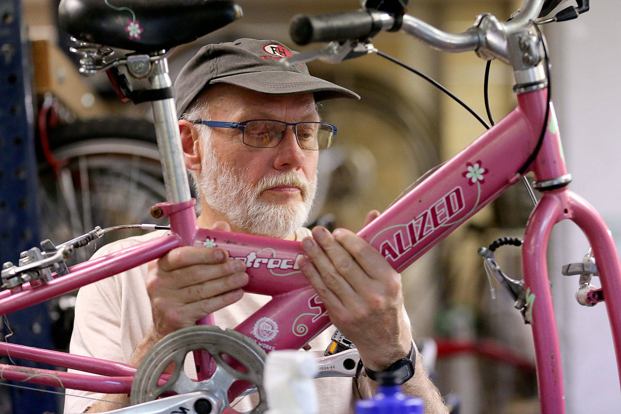 Don Sperlin works on a bike May 30, 2019 at Sharing Wheels Community Bike Shop in Everett. The nonprofit is organizing weekly volunteer work parties Tuesday and Thursday to fix children’s bikes through Dec. 10. (Kevin Clark / Herald file)