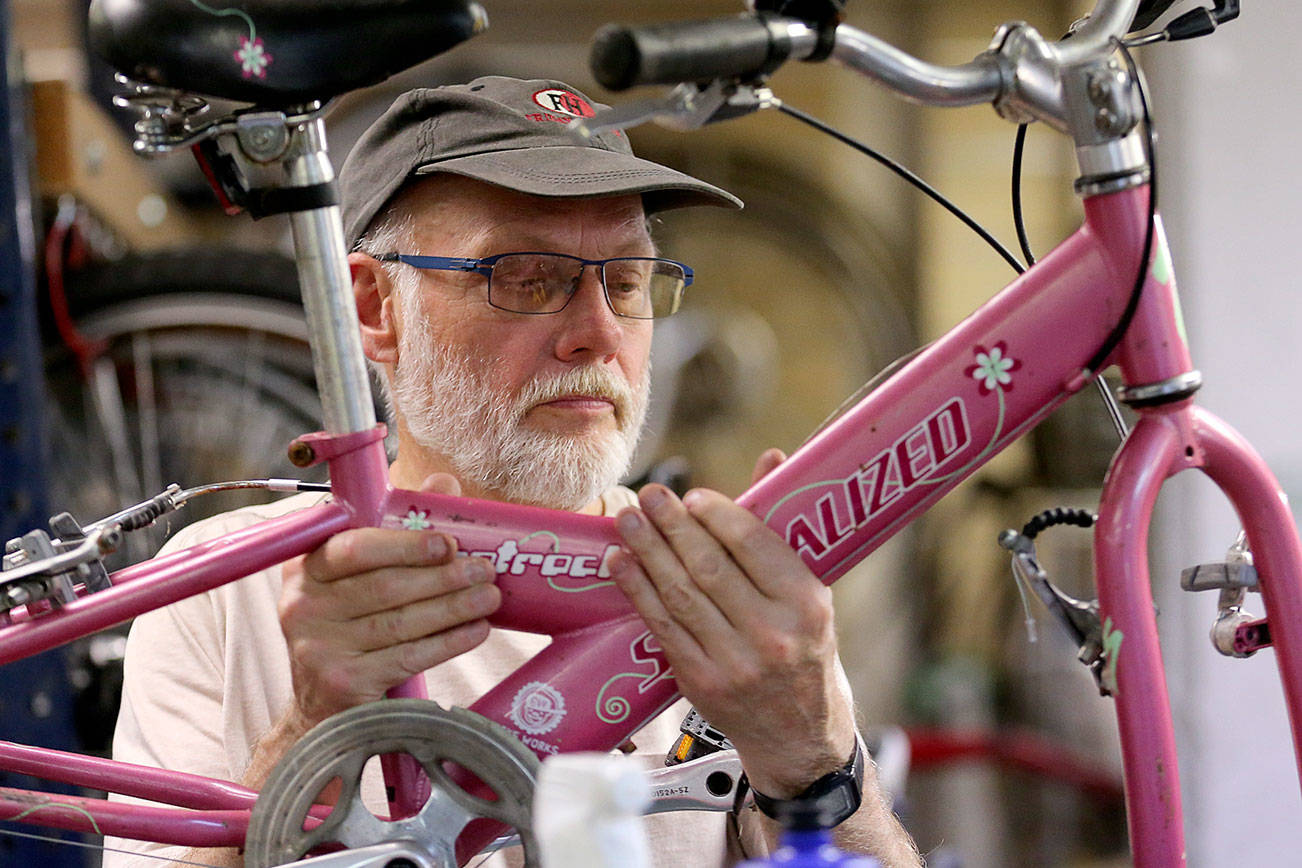 Don Sperlin works on a bike Thursday afternoon at Sharing Wheels Community Bike Shop in Everett on May 30, 2019. Sharing Wheels Community Bike Shop will be hosting it's 17th annual kids bike swap on June 9.  (Kevin Clark / The Herald)