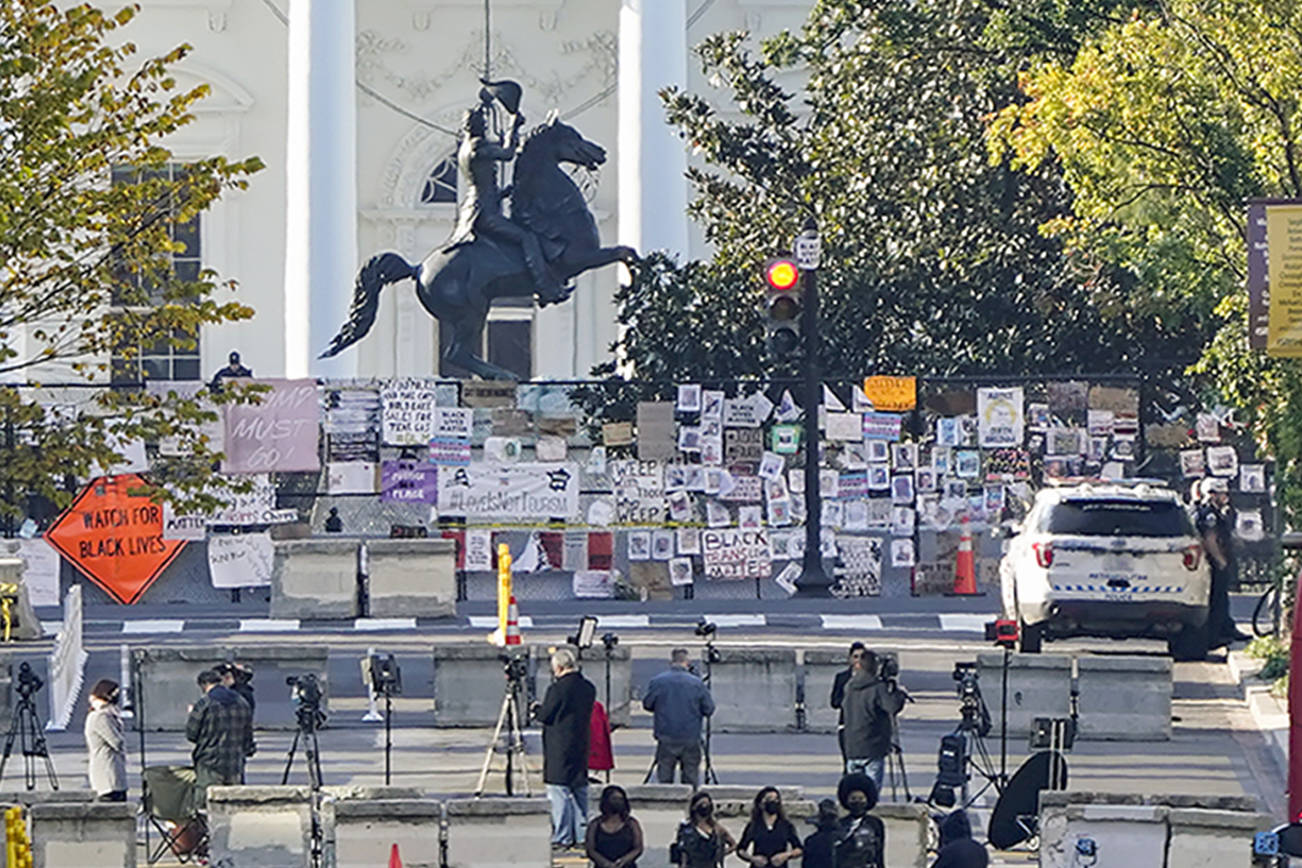 The White House is seen in Washington, early Tuesday, Oct. 6, 2020, the morning after President Donald Trump returned from the hospital where he was treated for COVID-19. Traffic moves along K Street NW as TV crews set up in Black Lives Matter Plaza. (AP Photo/J. Scott Applewhite)