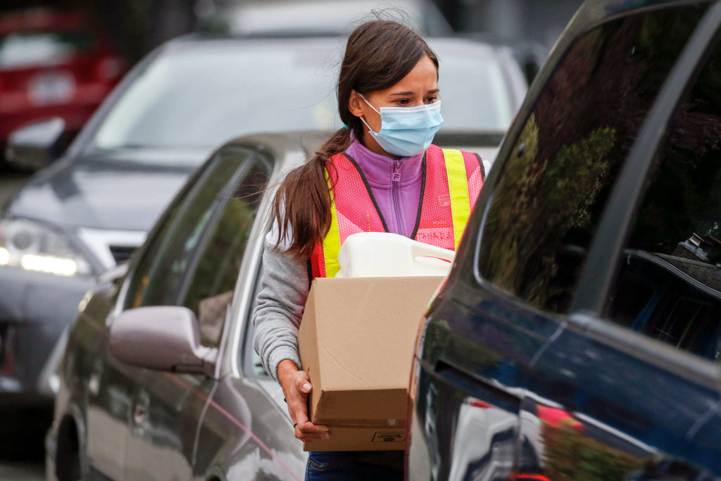 Tamara Kondzic waits to load a vehicle Friday morning at the Faith Food Bank at Faith Lutheran Church in Everett on October 9, 2020. (Kevin Clark / The Herald)
