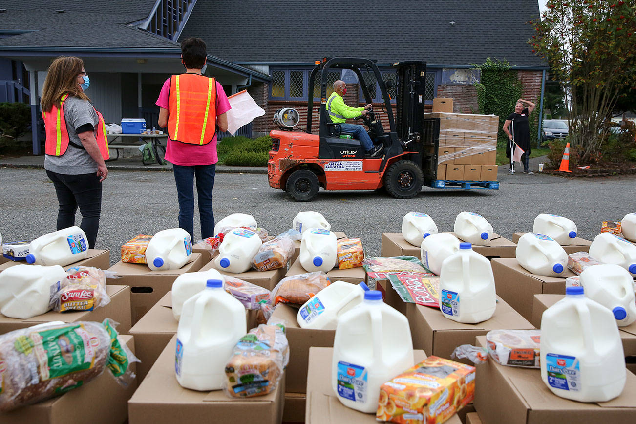 Volunteers await the next grouping a cars Friday morning at the Faith Food Bank at Faith Lutheran Church in Everett on October 9, 2020.   (Kevin Clark / The Herald)