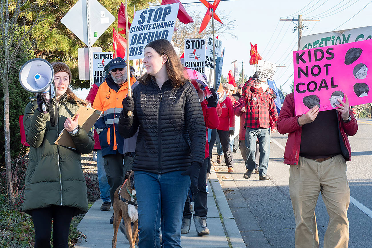 Caption: South Whidbey High School students Annie Philp, left, and Maggie Nattress lead a climate change demonstration in Freeland on Nov. 29, 2019. The two friends are founders of United Student Leaders. (Linda LaMar)
