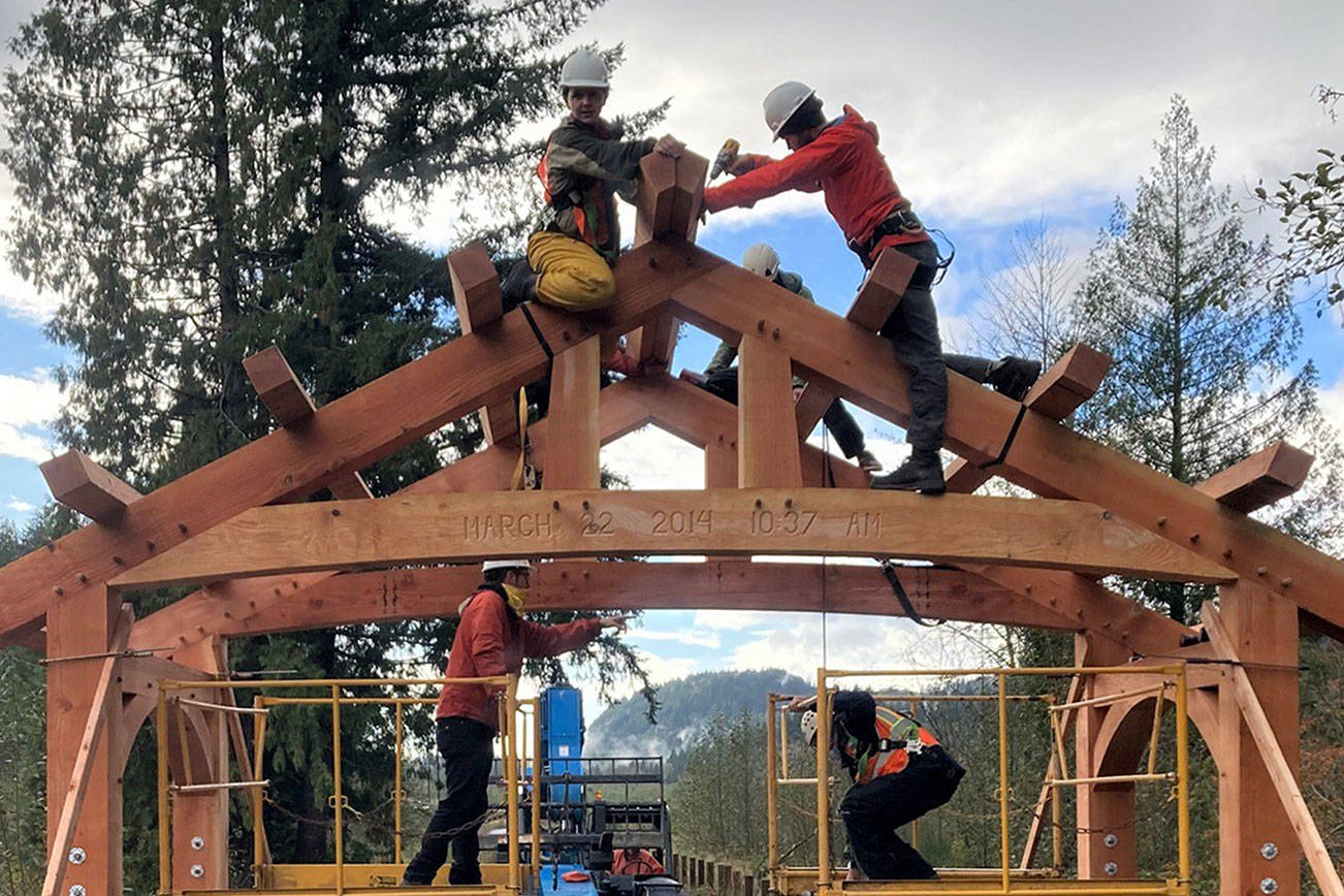 Volunteers with the Timber Framers Guild work Saturday to raise one of two Douglas fir portals at the site of the Oso Slide Memorial. The volunteers crafted the portals at the Monroe fairgrounds. (Snohomish County Parks photo)
