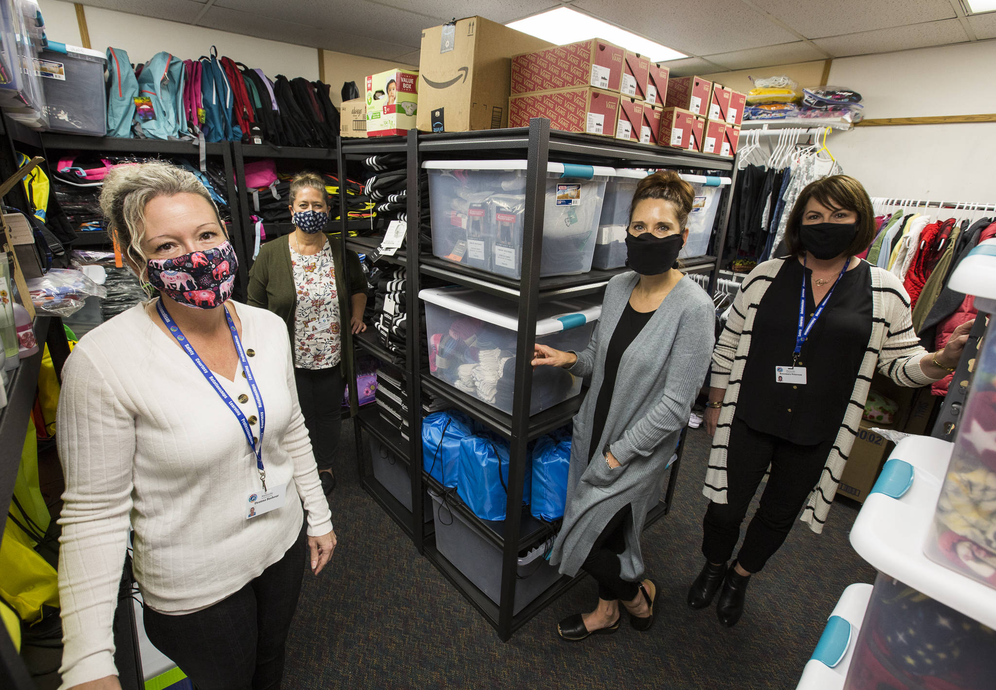From left, Marysville School District’s McKinney-Vento and foster care liaison Deanna Bashour, Andrea Wyatt, Larisa Koenig and Rosemary Peterson stand in a room full of donated items on Thursday. (Olivia Vanni / The Herald)