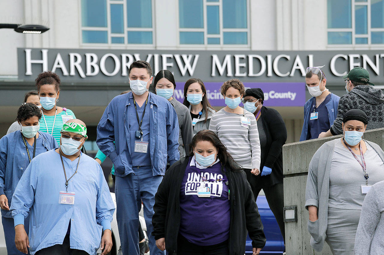 Health care workers and other staff walk out of Harborview Medical Center during a noon hour break on May 14 in Seattle. (AP Photo/Elaine Thompson)