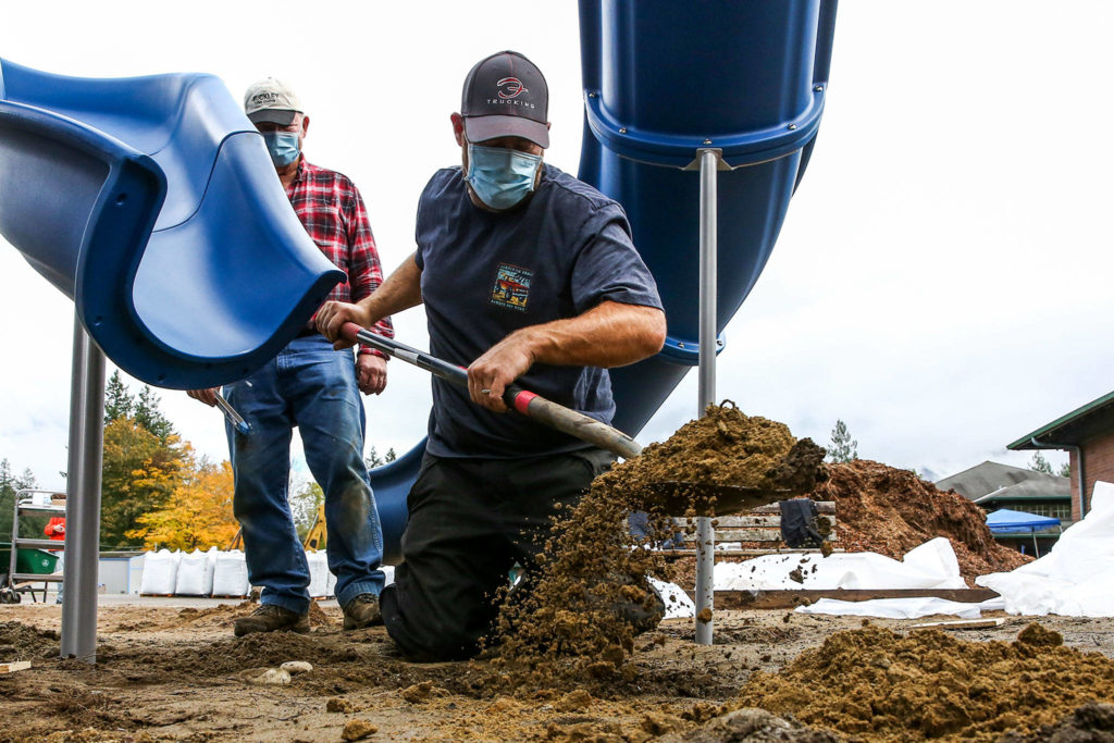 Justin Pierce digs to widen a footing for playground equipment Saturday afternoon at Gold Bar Elementary School in Gold Bar. (Kevin Clark / The Herald)
