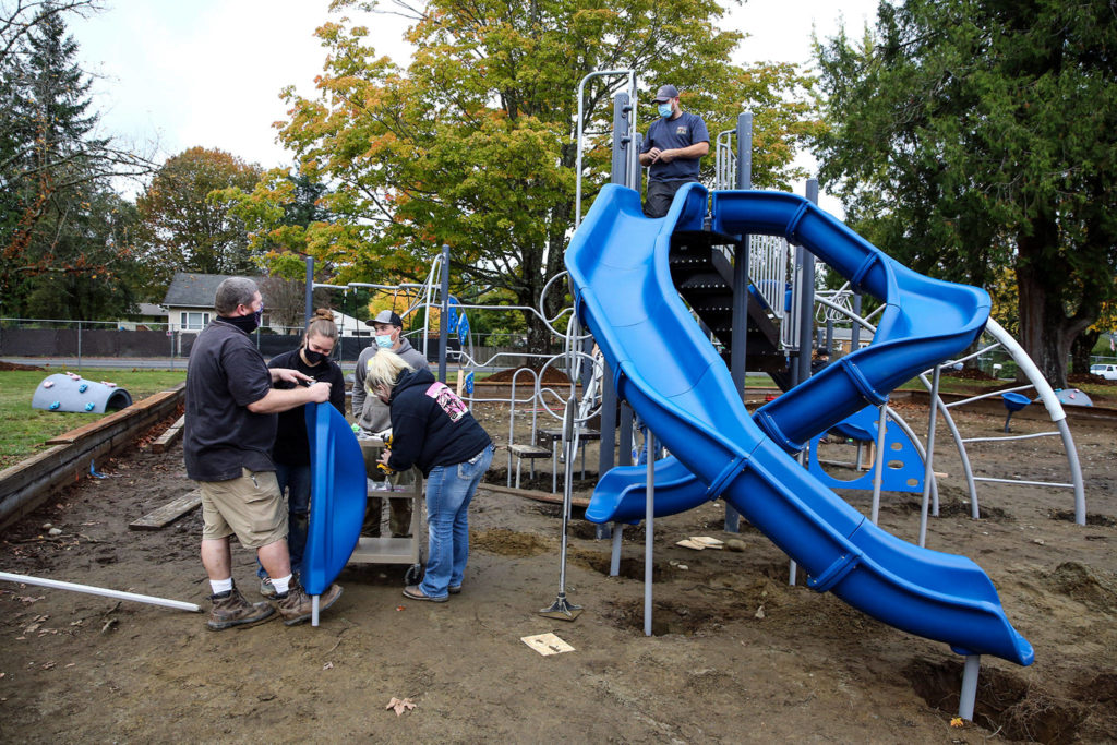 Volunteers assemble playground equipment Saturday afternoon at Gold Bar Elementary School in Gold Bar. (Kevin Clark / The Herald)
