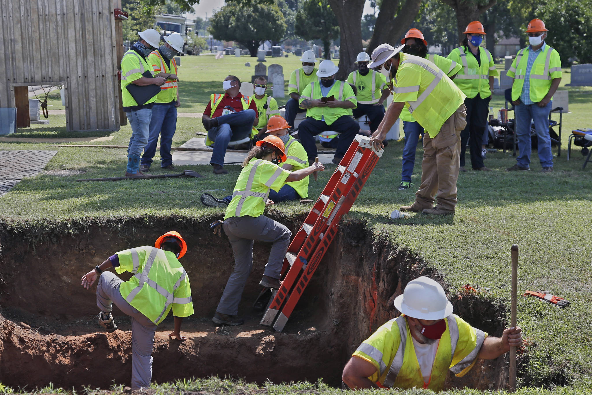 FILE - In this July 14, 2020, file photo, workers climb out of the excavation site as work continues on a potential unmarked mass grave from the 1921 Tulsa Race Massacre, at Oaklawn Cemetery in Tulsa, Okla. A second excavation begins Monday, Oct. 19, 2020, at a cemetery in an effort to find and identify victims of the 1921 Tulsa Race Massacre and shed light on violence that left hundreds dead and decimated an area that was once a cultural and economic mecca for African Americans. (AP Photo/Sue Ogrocki File)
