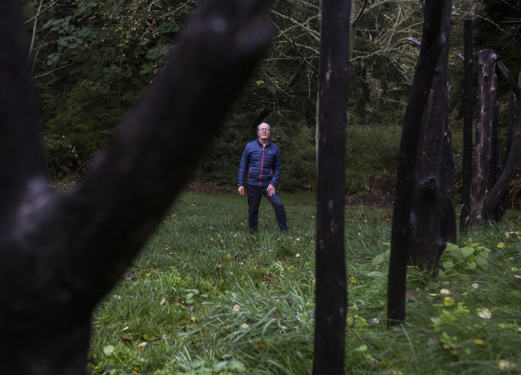 Environmental artist Chuck Pettis stands next to his “Ley Line” sculpture at Earth Sanctuary in Langley. Pettis founded the 72-arce park in 2000. (Olivia Vanni / The Herald)
