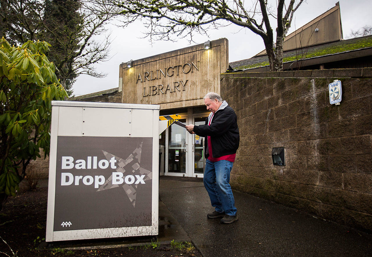 Kevin Duncan puts his ballot in the ballot drop box outside of the Arlington Library on Feb. 11, in Arlington. (Olivia Vanni / Herald file photo)