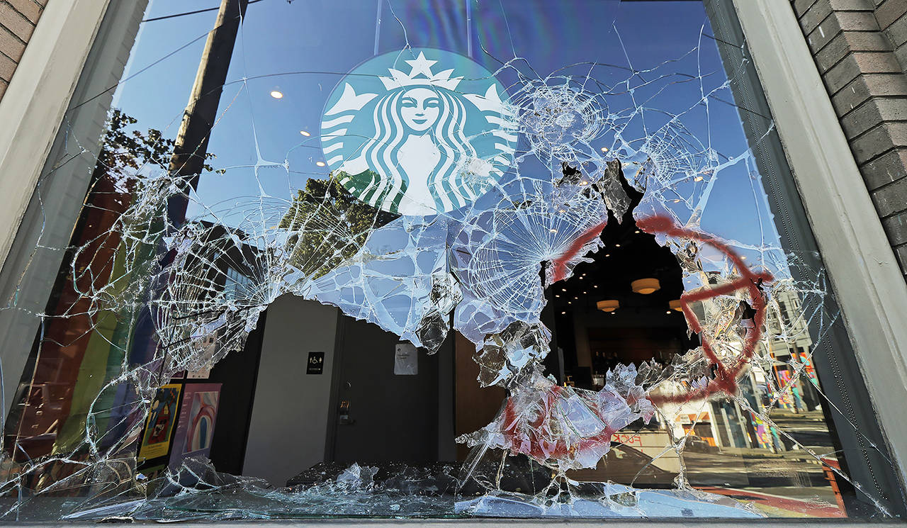 Protesters broke windows at a Starbucks store July 19 in Seattle’s Capitol Hill neighborhood. (AP Photo/Ted S. Warren)