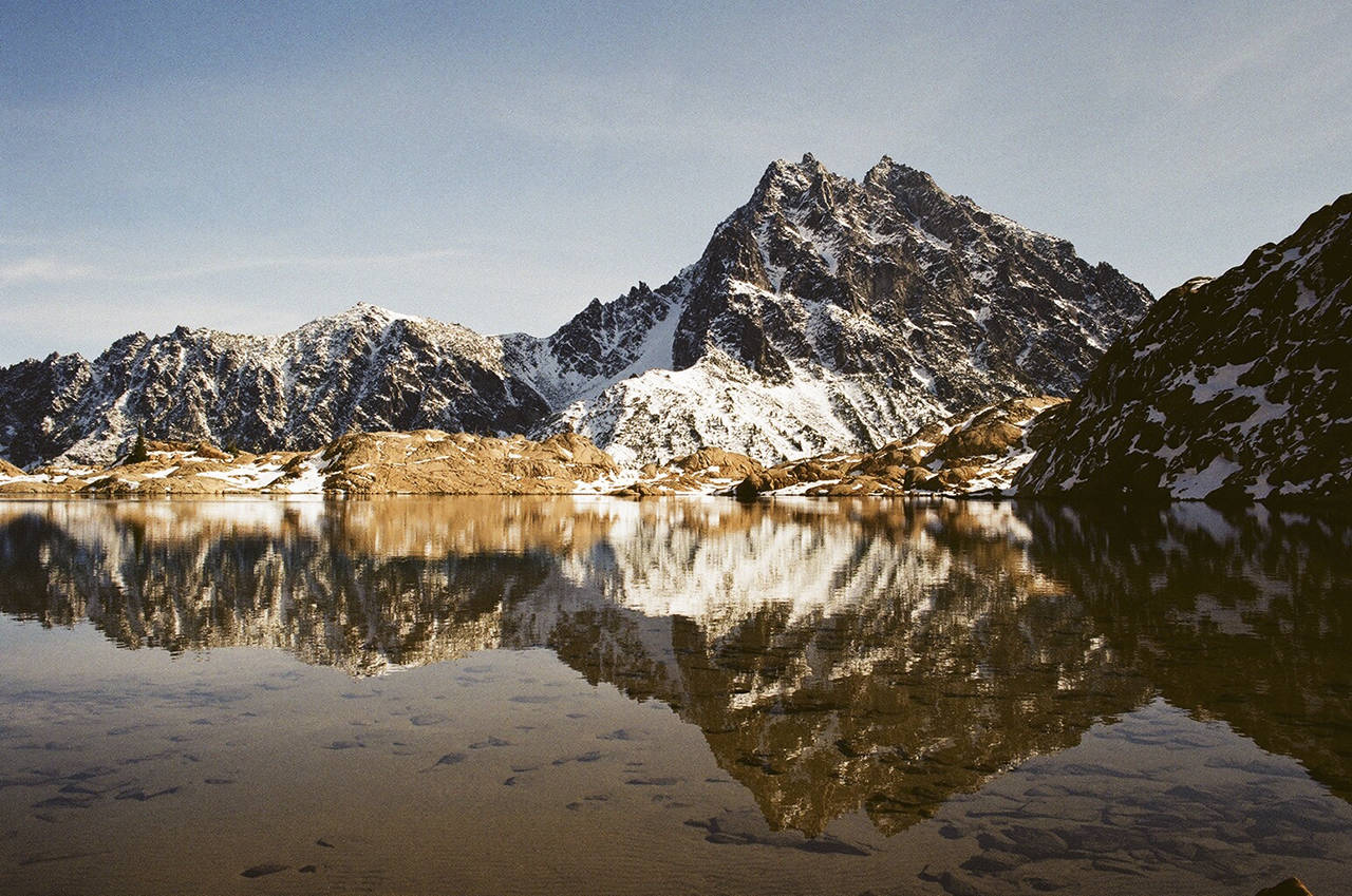 The top photo of Mount Stuart reflecting in Lake Ingalls near Cle Elum was taken with film, the bottom one with an iPhone. (Christina Hickman)