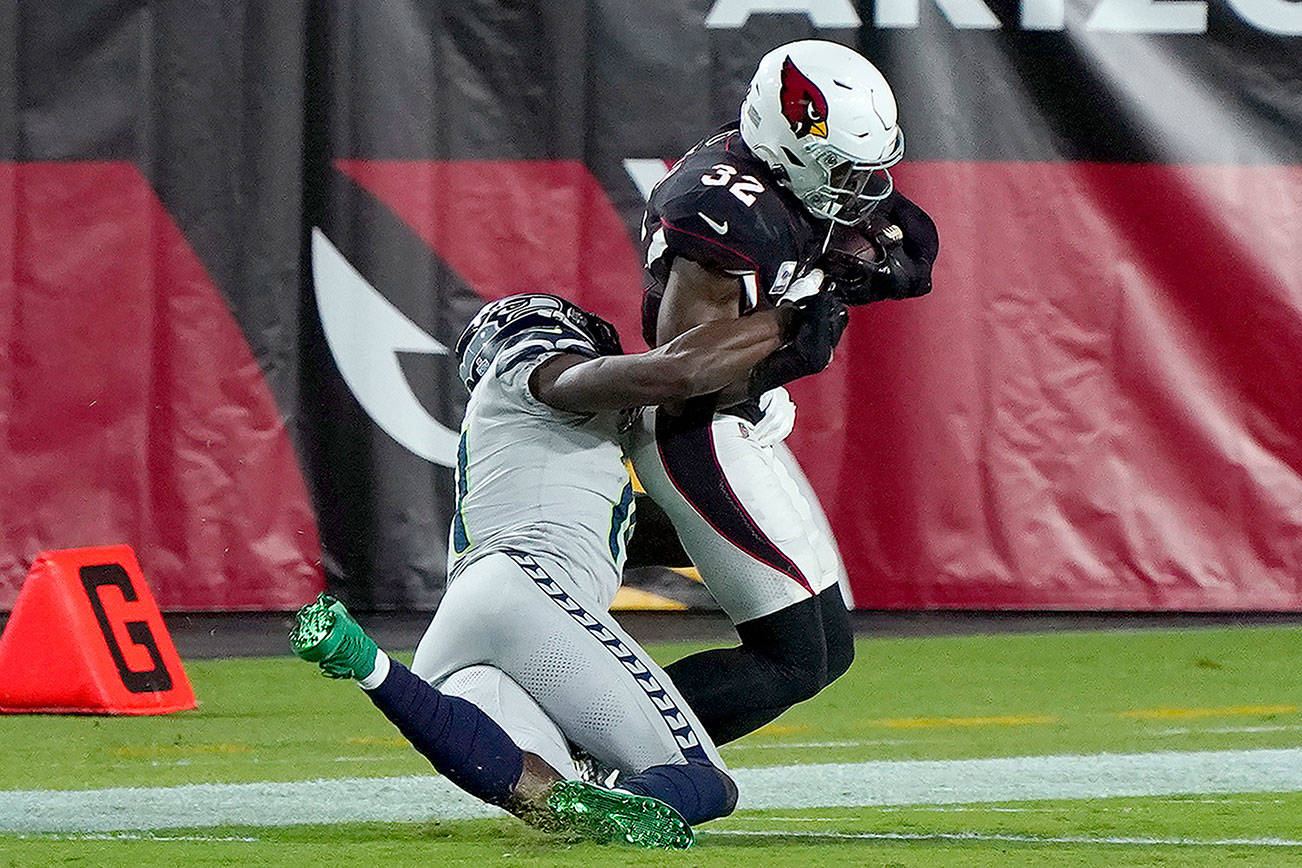 Seattle Seahawks wide receiver DK Metcalf tackles Arizona Cardinals strong safety Budda Baker (32) short of the goal line after Baker intercepted a pass during the first half of an NFL football game, Sunday, Oct. 25, 2020, in Glendale, Ariz. (AP Photo/Rick Scuteri)