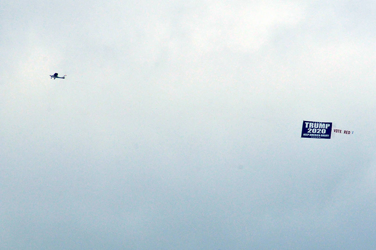 A plane tows a Trump banner Oct. 17 over Possession Sound in Everett. (Sue Misao / The Herald)