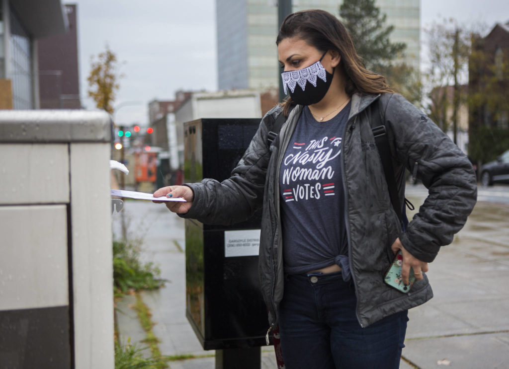Taryn Hauglie wears a Ruth Bader Ginsburg-inspired mask while she turns in her ballot at the Snohomish County Campus ballot box on Tuesday in Everett. (Olivia Vanni / The Herald)
