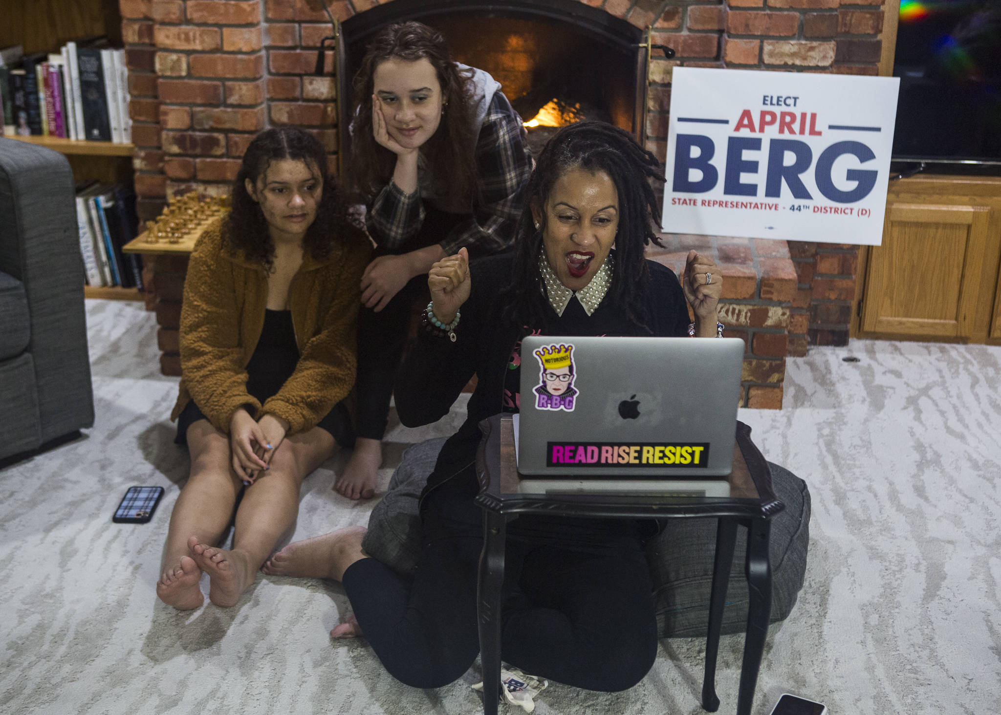Washington State Representative candidate April Berg (right) and daughters Simone Nowak (center), 16, and Camille Nowak (right), 14, react to election results putting her ahead of Mark James on Tuesday in Mill Creek. (Olivia Vanni / The Herald)