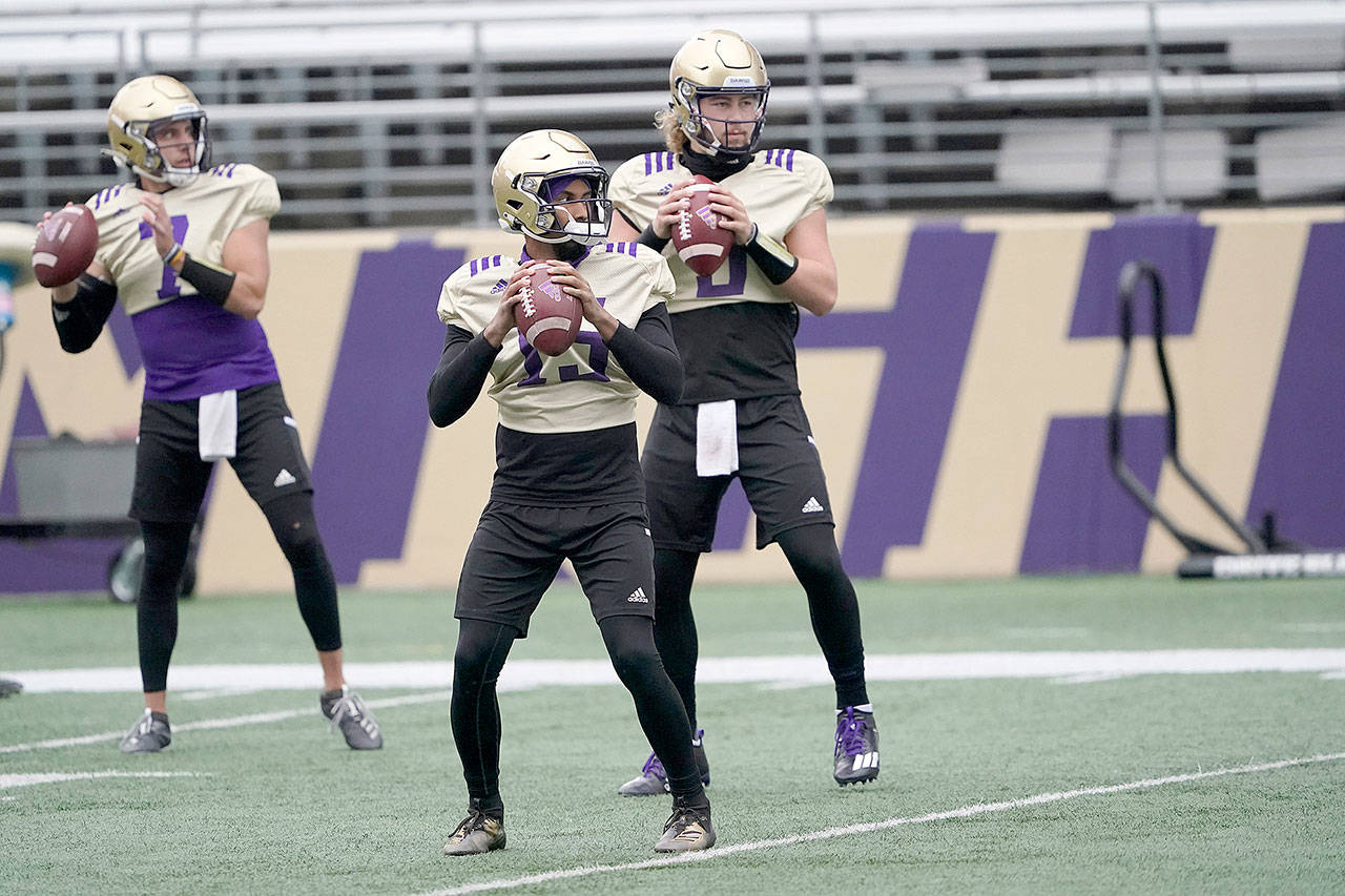 Washington quarterbacks Jaden Sheffey (center) Kevin Thomson (left) and Jacob Sirmon pass in a group during practice Oct. 16. (Ted S. Warren / Associated Press)