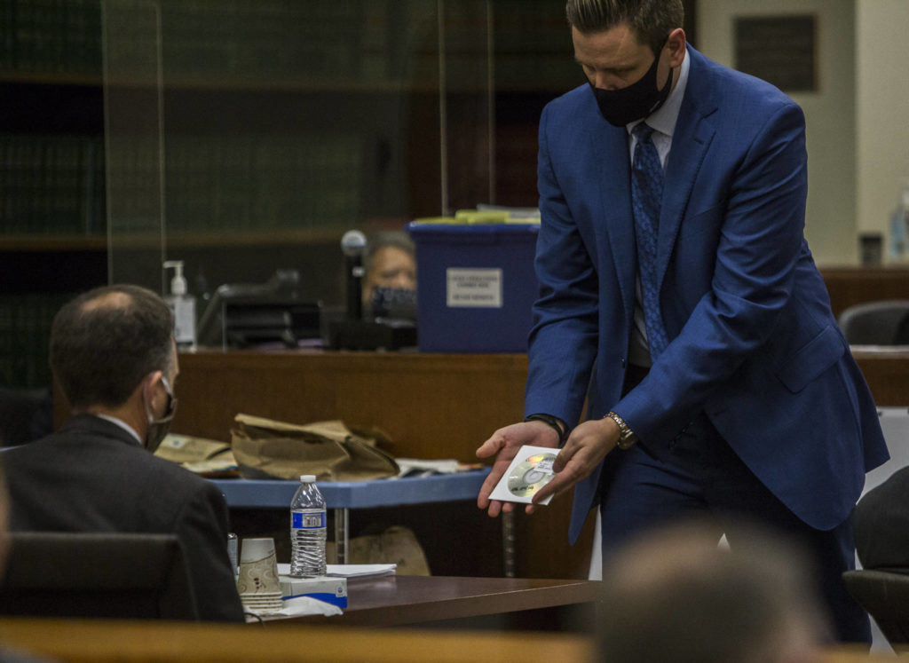 Snohomish County deputy prosecutor Bob Langbehn shows the defense a CD containing audio of a jail phone call made by Terrance Miller. (Olivia Vanni / The Herald) 
