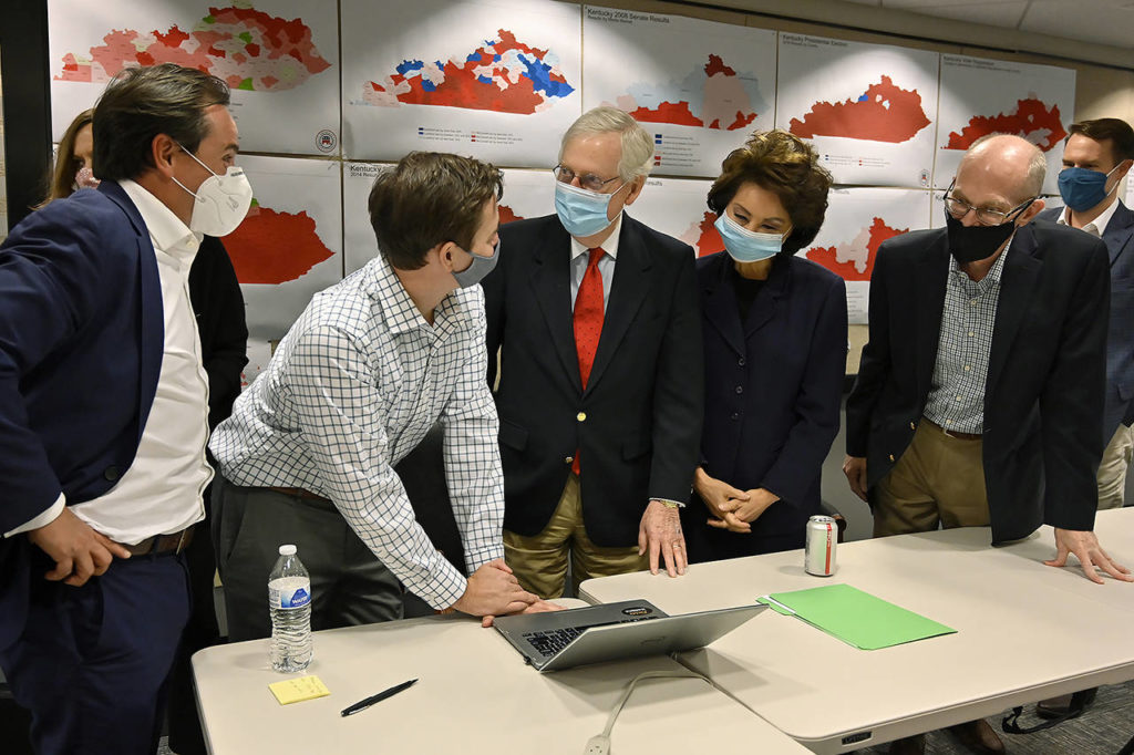 Republican Senate candidate Sen. Mitch McConnell (center) talks with a staff member as they gather around to watch the results of his reelection campaign in Louisville, Kentucky, on Tuesday. McConnell’s wife, Elaine Chao, stands next to him. (AP Photo/Timothy D. Easley)
