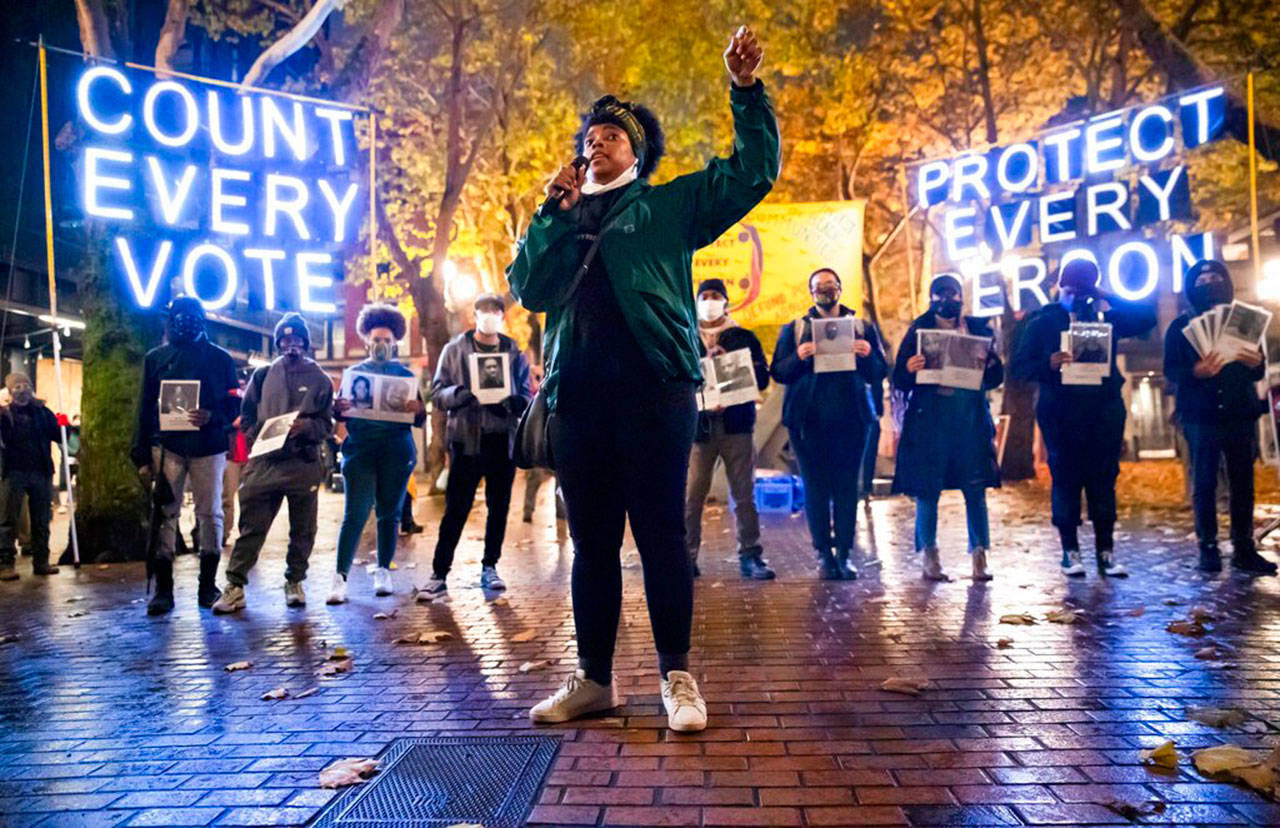 Travonna Thompson-Wiley, with Black Action Coalition, speaks at the Count Every Vote — Protect Every Person rally and march in Occidental Park in Seattle on Wednesday. A coalition of groups organized the event, which drew hundreds of people. The coalition demanded that every vote be counted and for an orderly transition of power, as well as the elimination the electoral college, defunding the police, eradicating ICE/CBP and investing in Black communities. (Erika Schultz / The Seattle Times)