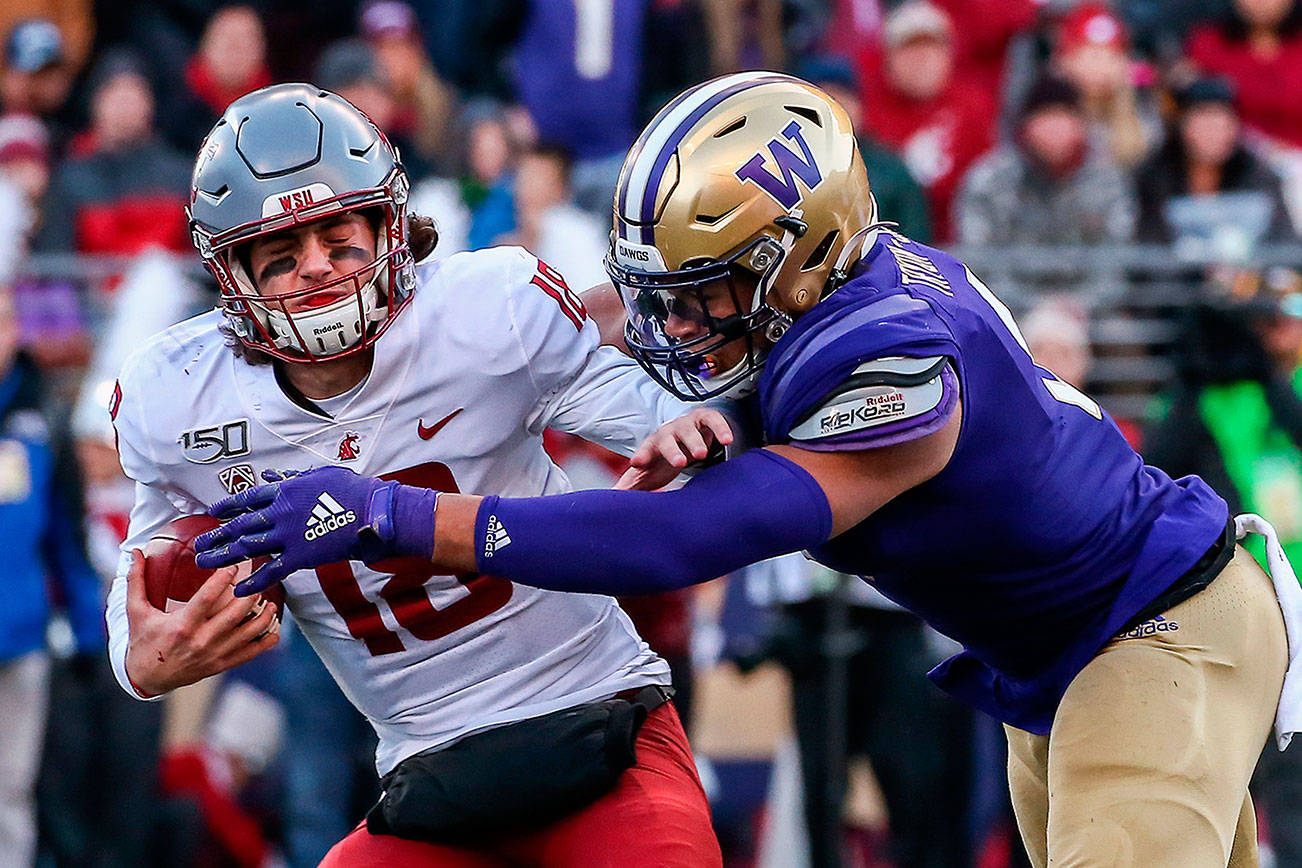 Washington State Cougars quarterback Anthony Gordon (18) is sacked by Washington Huskies linebacker Joe Tryon (9) during last year’s Apple Cup at Husky Stadium. The Huskies won 31-13. (Kevin Clark / The Herald)